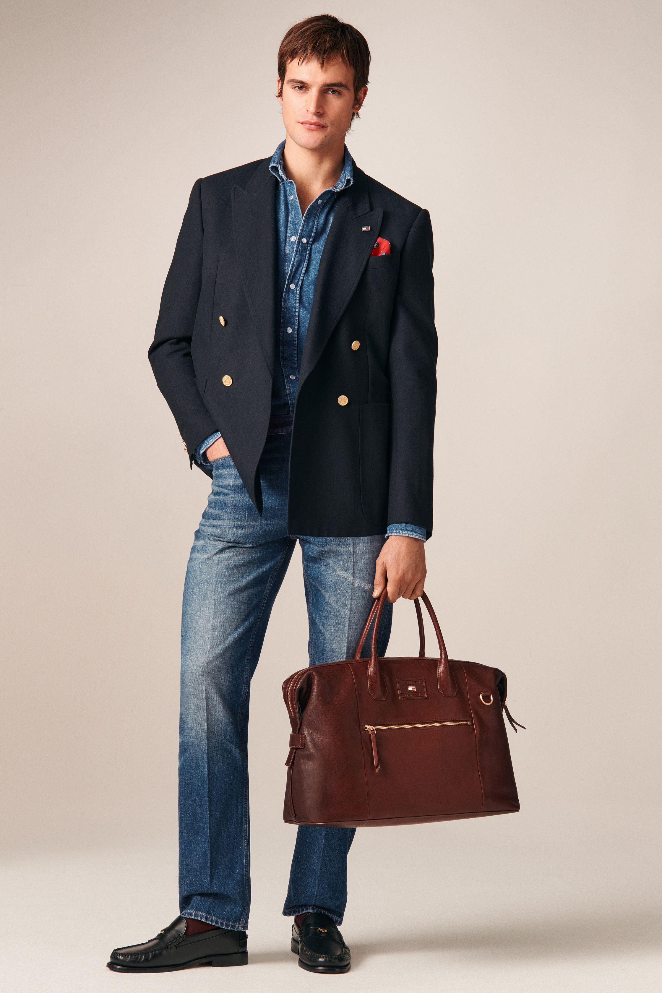 Tommy Hilfiger 26FW 男装回到品牌最擅长的美式学院与都市绅士语境。条纹针织、飞行夹克、羊羔毛外套与双排扣大衣共同勾勒出成熟却不老派的美式精英形象。色彩以海军蓝、酒红、驼色为核心，强化可靠、易穿的商业属性。系列不追求先锋表达，而是精准回应全球市场对“经典升级版”的现实需求-顽石频道趋势研究